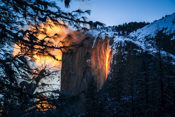 A natural phenomenon known as "firefall" at Yosemite National Park, where the setting sun illuminates Horsetail Fall, making it appear like flowing lava.